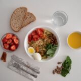 Farfurie echilibrată cu legume colorate, o porție de cereale integrale și o sursă de proteine, pe o masă luminoasă