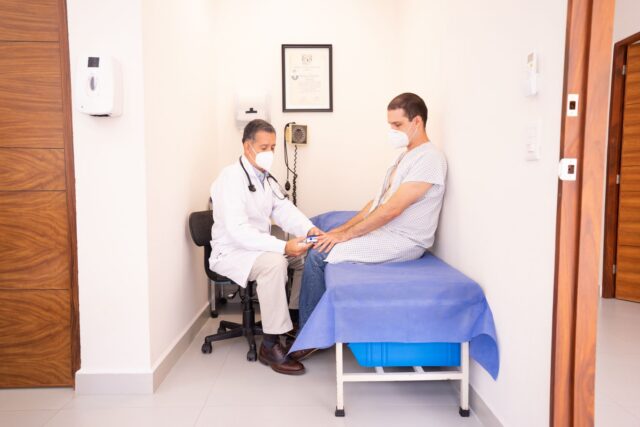 Trusă de prim ajutor deschisă pe o masă, cu bandaje, comprese sterile, foarfece și termometru